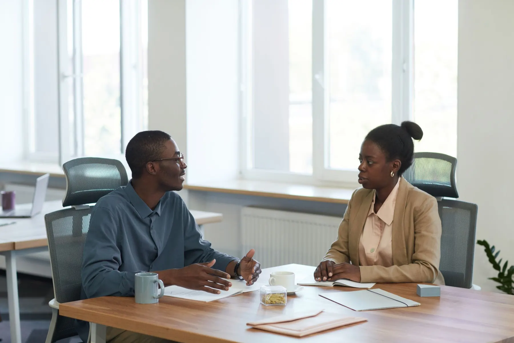 A Sanctuary adviser talking through cover with a client across a desk