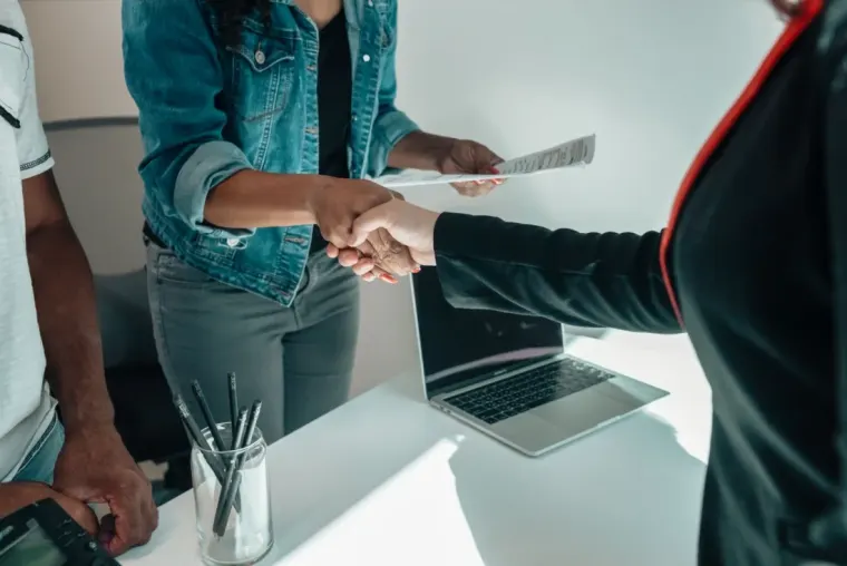 Two people shaking hands over an agreement